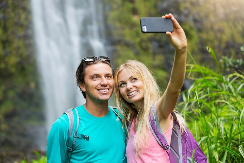 a couple taking a selfie with waterfall in the background