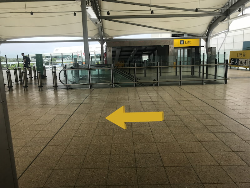 First level of the skywalk with yellow arrows pointing left.