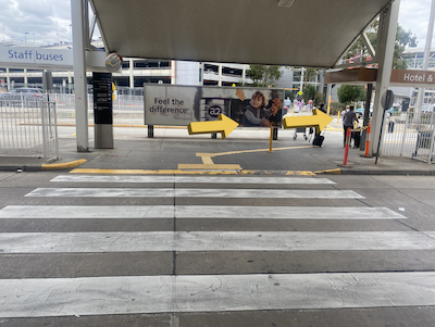 Airport crosswalk with people to the right.