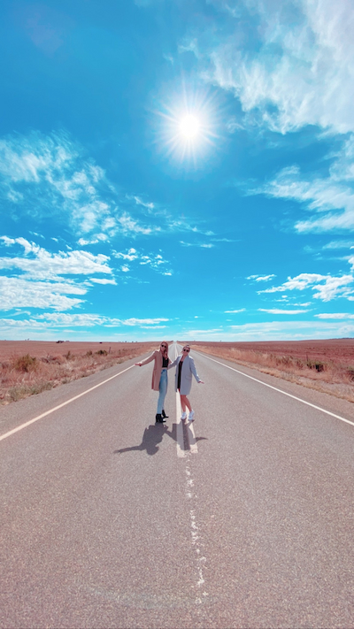 Two girls standing in the middle of the highway