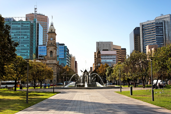 Water fountain in a park with the city in the background on a sunny blue sky day.