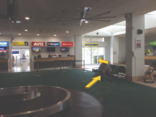 Interior of an airport - yellow arrow pointing straight towards the exit,