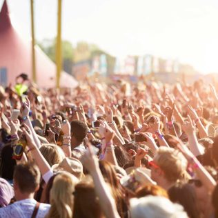 Audience at outdoor music festival | Featured image for the Must See Regional Festivals blog for East Coast Car Rentals.