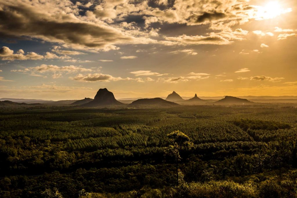 View of Glasshouse Mountains at sunset | Featured image for the Best Country Towns to Visit in Queensland blog from East Coast Car Rentals.