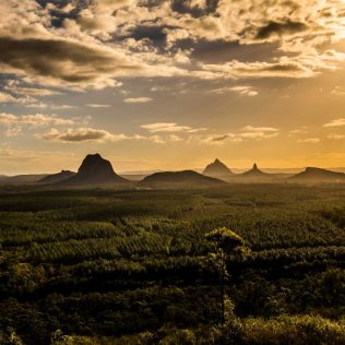 View of Glasshouse Mountains at sunset | Featured image for the Best Country Towns to Visit in Queensland blog from East Coast Car Rentals.