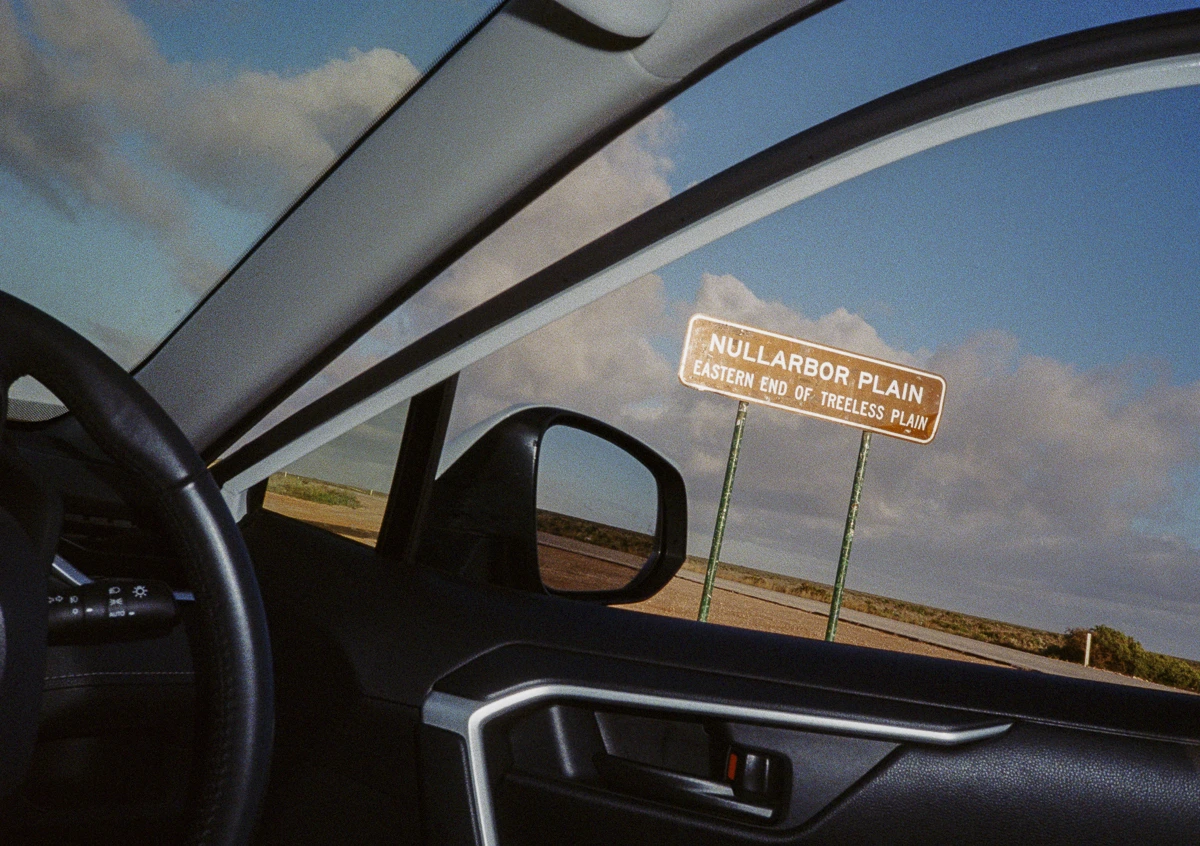A road trip viewed through the frame of a car window.
